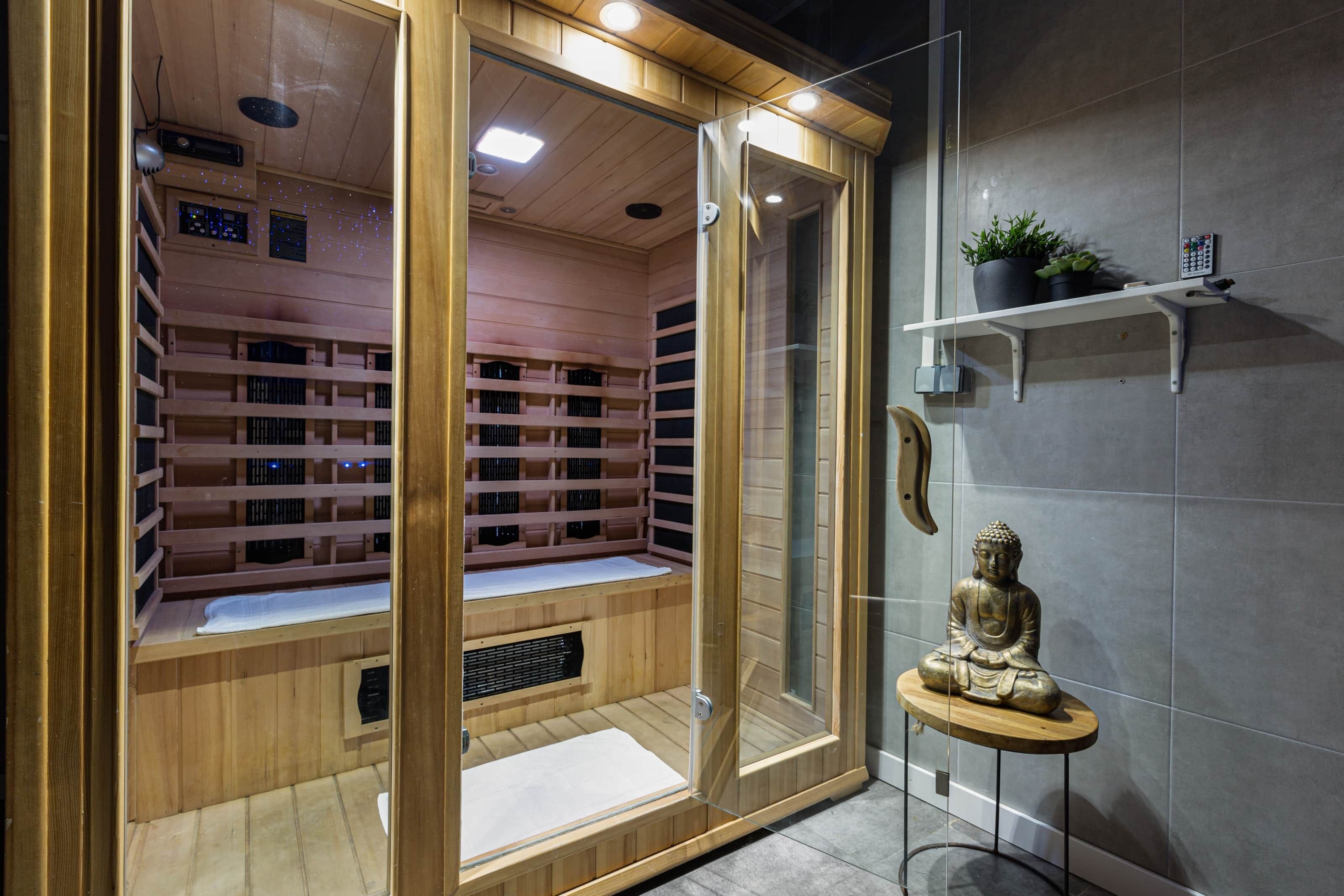 Ein Sauna-Raum mit Holzregalen, einer Glastür und einer Statue.
