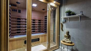 A sauna room with wooden shelves, a glass door, and a statue.