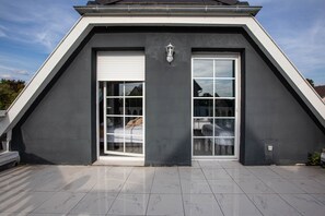 Ein modernes Gebäude mit dunkler Fassade, großen Fenstern und weißem Rahmen.