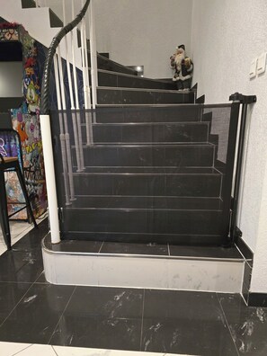 A staircase with a black handrail and white steps, leading to an upper floor. - Villa Ours – Private spa, games room, 15 guests (Ittenheim)