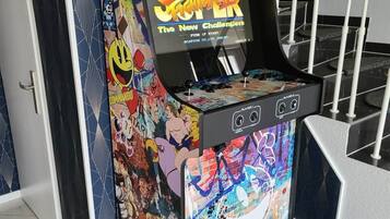 Une borne d’arcade aux couleurs vives, dotée d’un design pixelisé attrayant, sur laquelle figure le titre « Street Fighter II : The New Challengers » et l’inscription « APPUYEZ POUR DÉMARRER ».