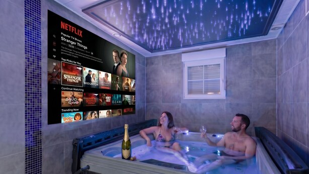 A room with a large screen displaying a Netflix interface, a hot tub, and a bottle of champagne. - Villa 200m² with private spa, barbecue, table football (Ittenheim)