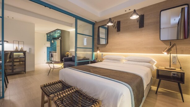 A modern bedroom with a large bed, bedside tables, a bench, and a mirror. - CHAYOFA SUITES - STUDIO (Santa Cruz de Tenerife)