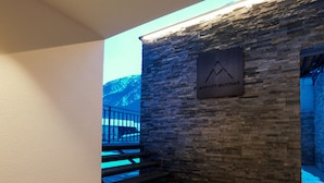 A staircase leading to a stone wall with a sign reading "Appartments Muchas."