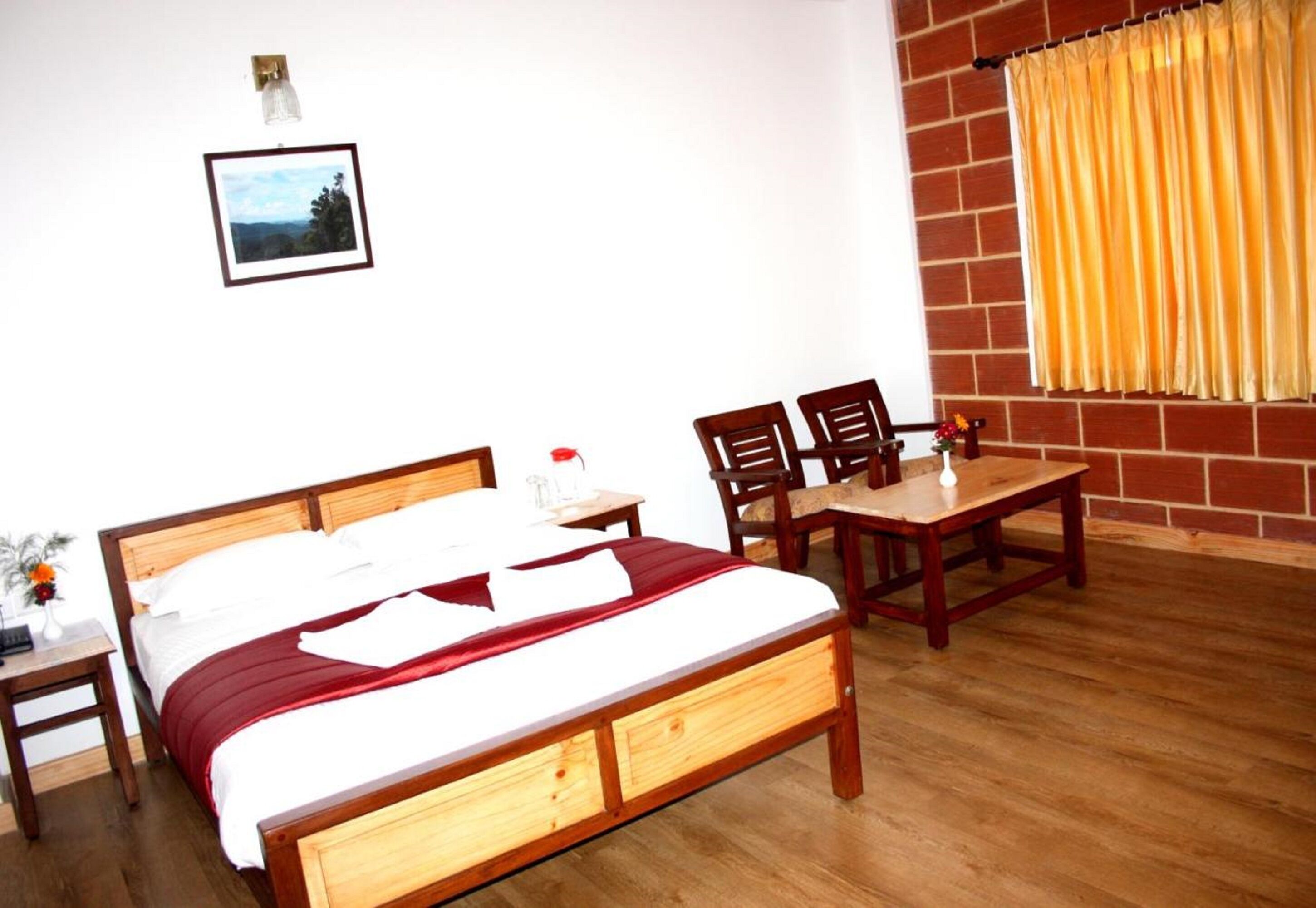 A wooden bed with a red blanket, a bedside table with a lamp, and a chair.