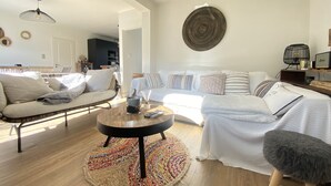 A modern living room with a sofa, a coffee table, and a patterned rug. - Cocooning villa in a quiet neighborhood near downtown La Teste (La Teste-de-Buch)