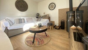 A cozy living room with a sofa, a round coffee table, a rug, a fireplace, and a clock on the wall. - Cocooning villa in a quiet neighborhood near downtown La Teste (La Teste-de-Buch)