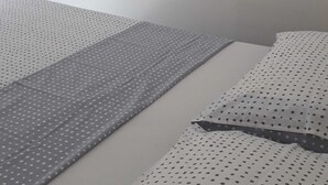 Un dormitorio con cama, cómoda, espejo y decoración de aves en ramas.
