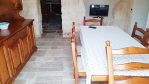 A room with a wooden bed, a television on the wall, and a wooden cabinet. - Trulli in Monopolitan countryside  (Puglia)