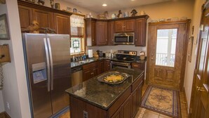 A kitchen with wooden cabinets, stainless steel appliances, and a central island.
