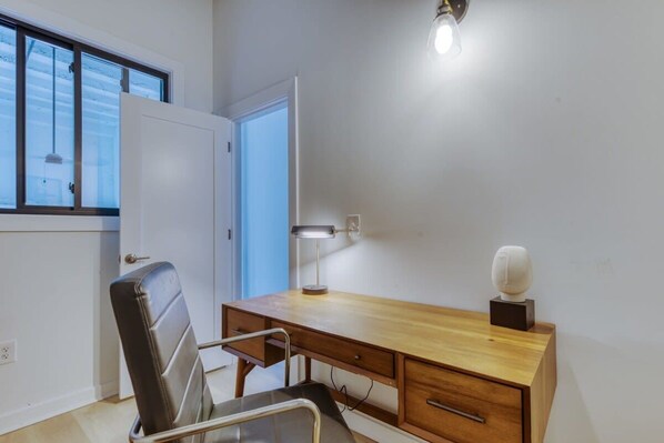 A small office with a desk, chair, and a lamp.