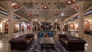A spacious lobby with leather sofas, a central coffee table, and pendant lighting. - Sosuite | 2BR Loft w W/D, Gym, Lounge (Philadelphia)