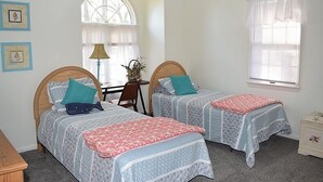 A bedroom with two single beds, a desk, and a chair. - Nature's Retreat- Waterview with Shared Crabbing Pier (Chincoteague)