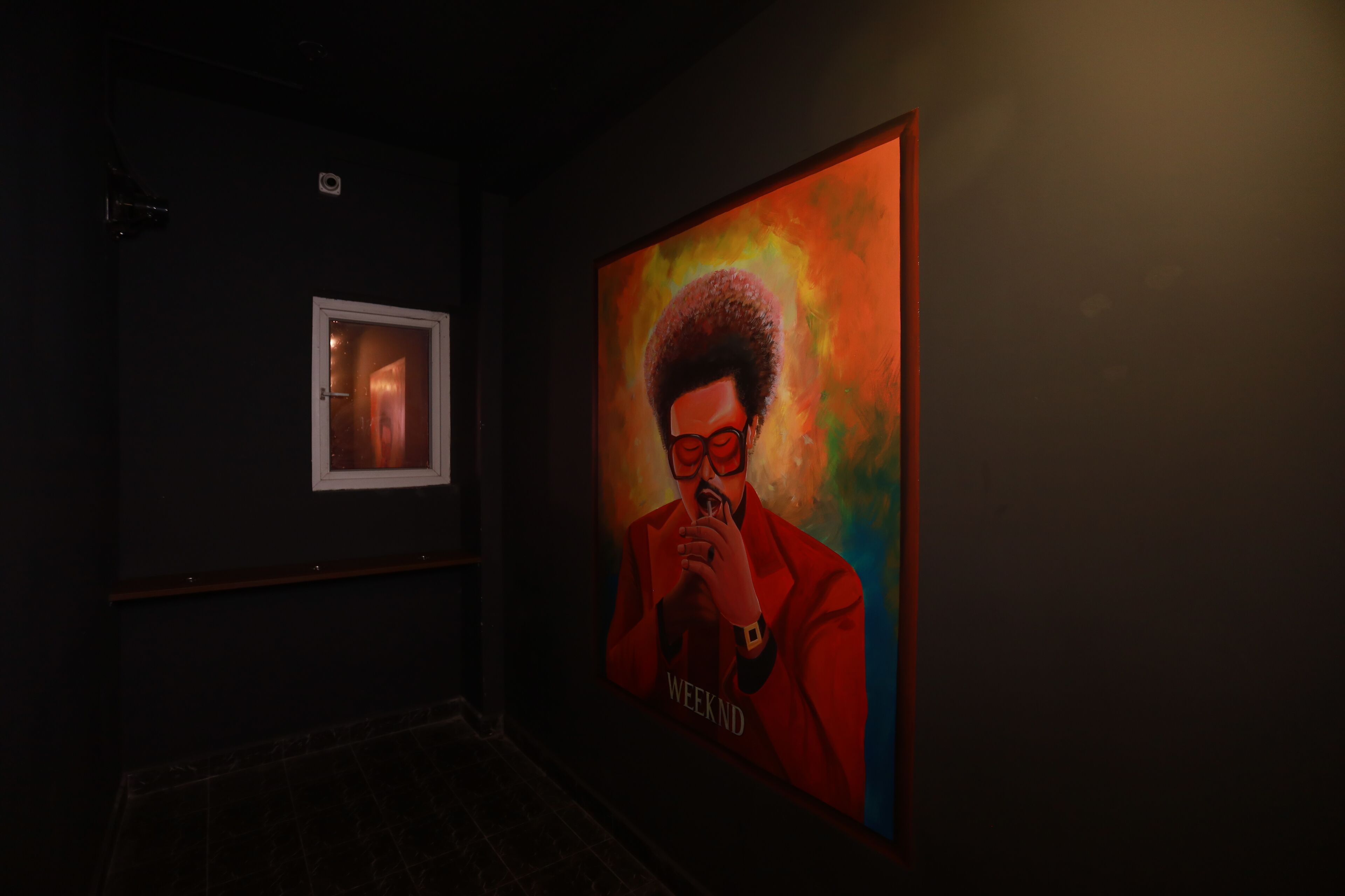 Un pasillo con un cuadro enmarcado en la pared y una pintura grande.