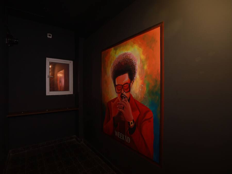 Un pasillo con un cuadro enmarcado en la pared y una pintura grande.