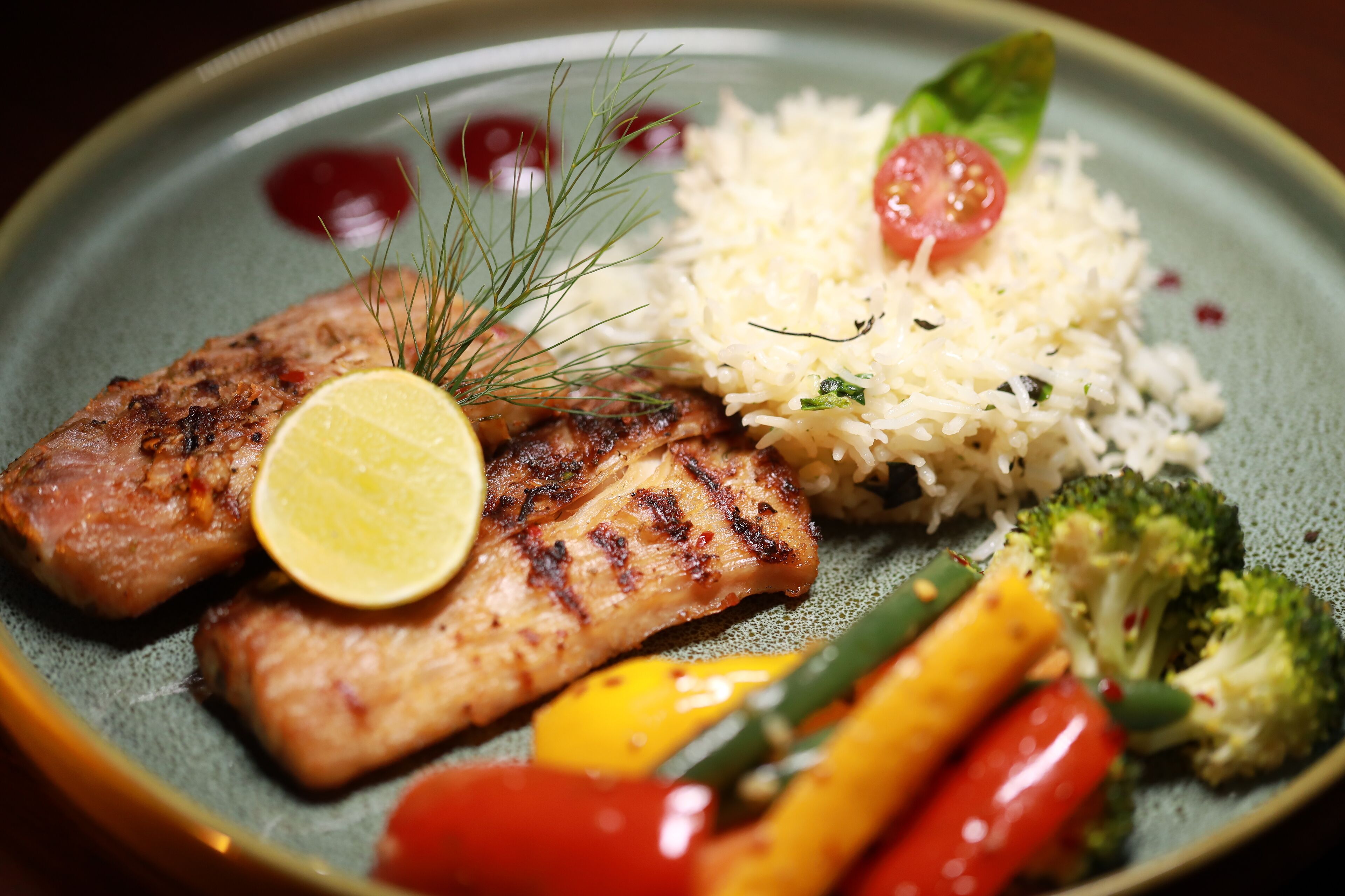 A plate with grilled fish, rice, and vegetables.