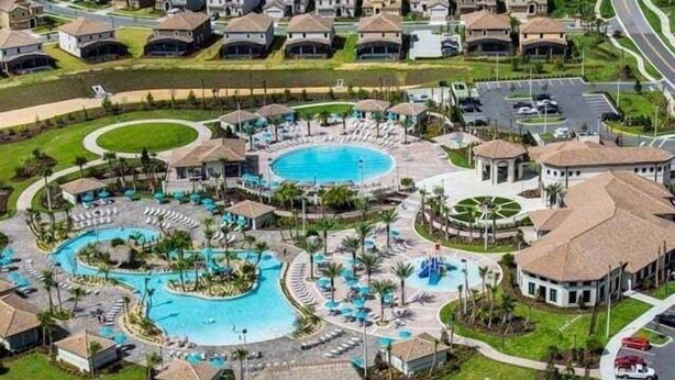 A resort with a central pool, multiple guest villas, and a parking area. - 8 Bedroom Movie Theater In Home Champions Gate! 8 Villa by RedAwning (Davenport)