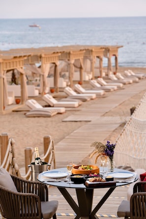 A beachside dining area with a table set for two, overlooking the sea. - Liu Resorts - All inclusive (Manavgat)