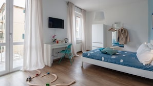 A bedroom with a bed, desk, chair, and a TV. - Suites Colombo 32 (La Spezia)
