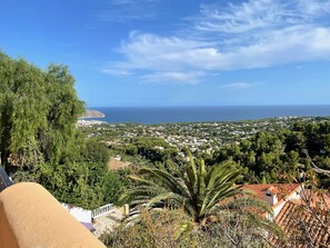 A coastal town with a view of the sea and dense greenery.