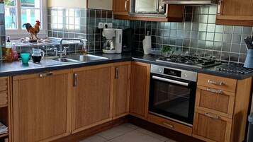 A kitchen with wooden cabinets, a microwave, a coffee maker, and a stove.