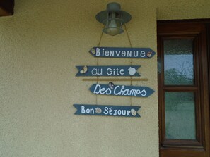 A wall with signs reading "Bienvenue," "Au Gîte," "Des Champs," and "Bon Séjour," indicating a welcoming sign for guests. - Villa des Champs (Graignes-Mesnil-Angot)