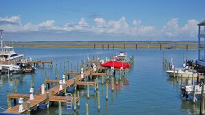 Un puerto deportivo con muelles de madera y barcos, incluyendo un barco rojo en el centro.