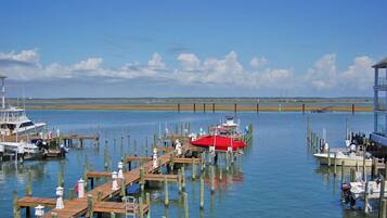 A marina with wooden docks and boats, including a red boat in the center.