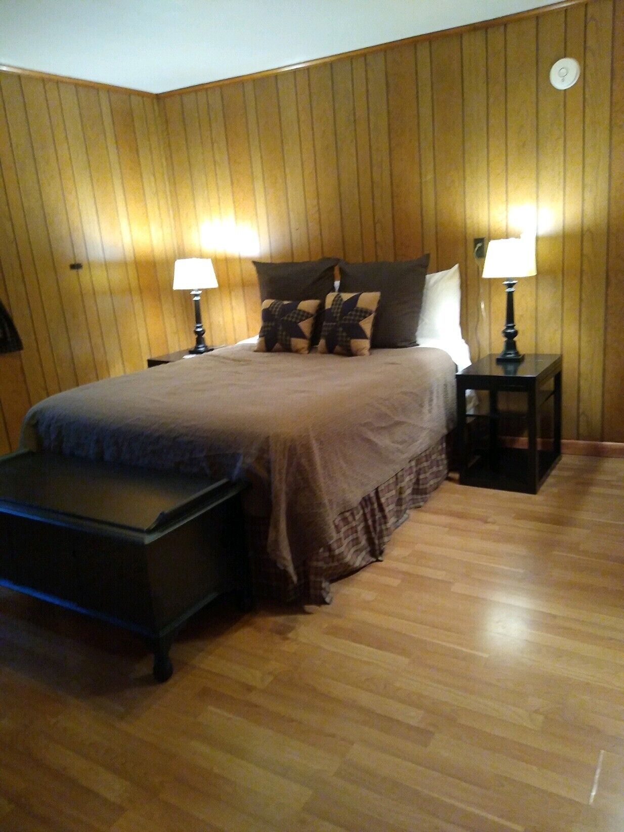 A bedroom with a bed, two bedside tables, and a nightstand.