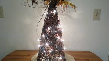 Una struttura decorativa a forma di albero con luci e una stella su un tavolo di legno.