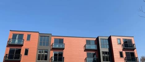 Un immeuble à plusieurs étages doté de balcons et de grandes fenêtres.