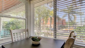 A dining area with a table, chairs, and a potted plant.