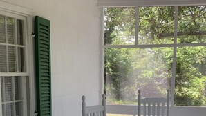 A porch with two rocking chairs, one with a green leaf-patterned pillow. - Dock and Boat access Home on the Eastern Shore  Virginia (Belle Haven)