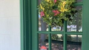 A green door with a window, a sign indicating electronic security, and a hanging floral arrangement. - Dock and Boat access Home on the Eastern Shore  Virginia (Belle Haven)