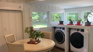 A compact kitchen with a dining area, built-in appliances, and large windows. - Dock and Boat access Home on the Eastern Shore  Virginia (Belle Haven)