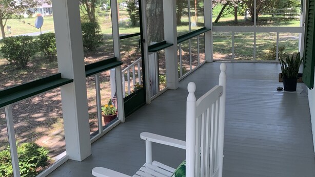 A covered porch with white railings and a white rocking chair. - Dock and Boat access Home on the Eastern Shore  Virginia (Belle Haven)
