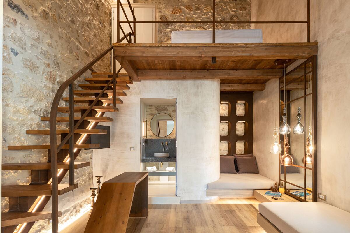 Un intérieur moderne avec un escalier en bois, un espace salon central et un grand miroir.