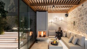 A modern living room with a fireplace, a sofa, and a coffee table. - Inotropes Boutique Suites - Adults Only (Archanes-Asterousia)