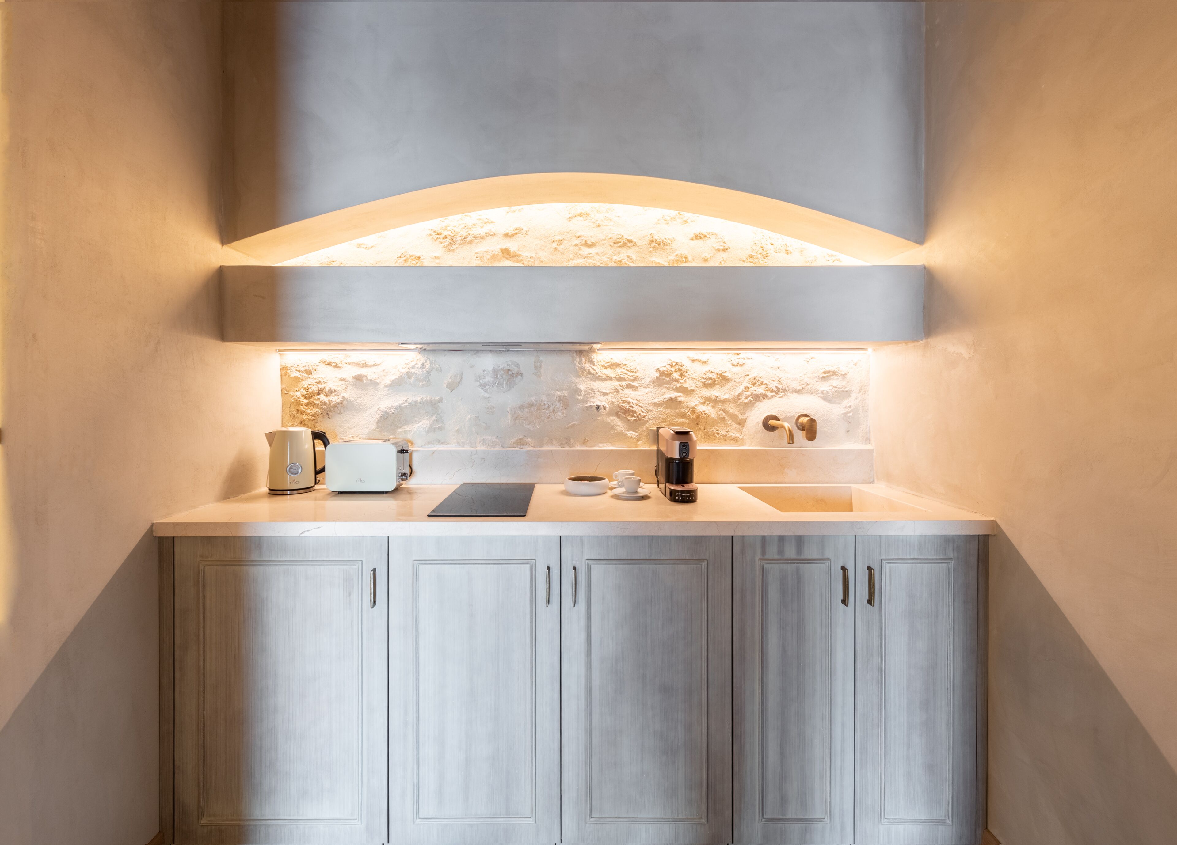 A modern kitchen with a built-in island, a coffee machine, and a sink.