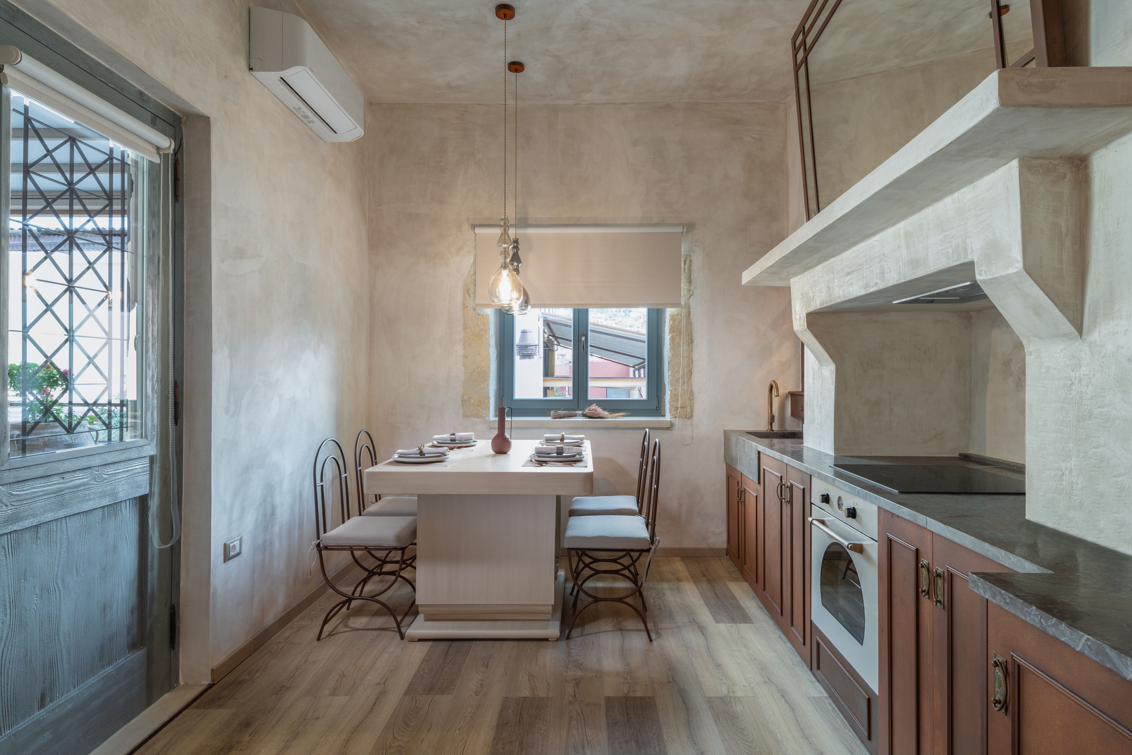 Una cocina compacta con una isla central, horno empotrado y un ventanal que proporciona luz natural.
