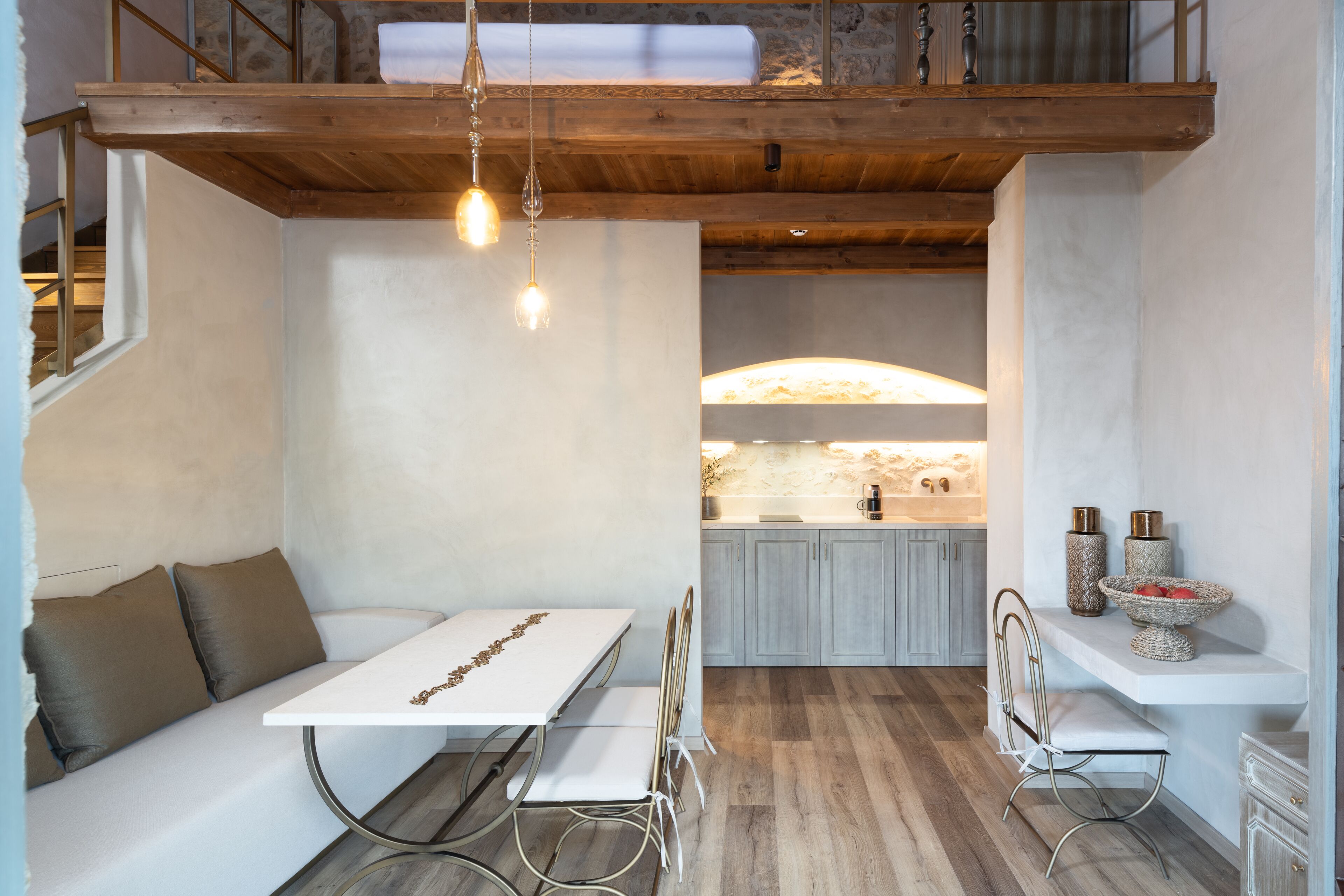 A modern kitchen with a white countertop, wooden ceiling beams, and a built-in oven.