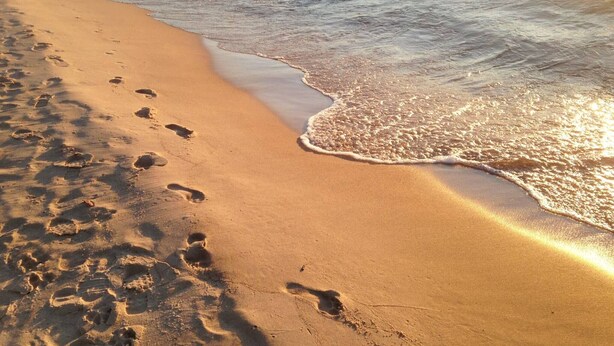 A beach with footprints leading into the water. - Harbor Hideaway - 3 bedroom cottage. (South Haven)