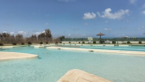 A swimming pool area with clear water, a wooden fence, and a gazebo in the background. - Dreamy Sunset - Appartement (Playa Honda)