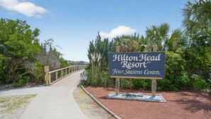 Un panneau indiquant l’emplacement du Hilton Head Resort, avec un chemin menant à l’entrée.
