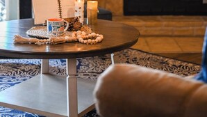 Una habitación acogedora con chimenea, un espejo redondo y un letrero que dice 'agradecido'.