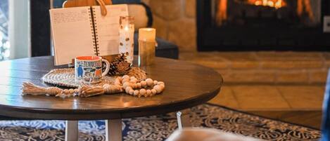 A cozy room with a fireplace, a round mirror, and a 'thankful' sign above it.