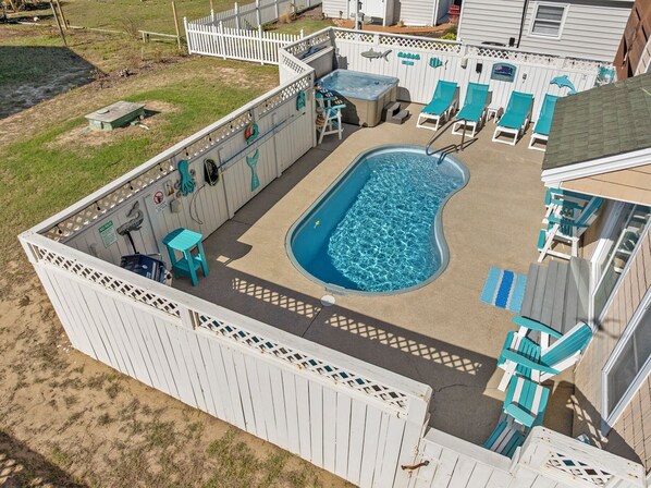 A backyard with a swimming pool, lounge chairs, and a hot tub. - Starry Nights: Oceanview, Private Pool, Hot Tub, Rec Room, Dog-friendly (Kill Devil Hills)