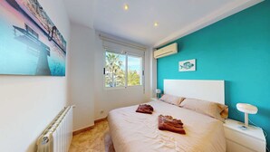 A bedroom with a bed, a nightstand, a window, and a painting on the wall. - Villa Frente al mar con Vistas, Terraza, Barbacoa y Piscina con spa (Bahía de Jávea)