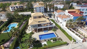 A large, multi-story hotel with a central courtyard, a swimming pool, and multiple balconies. - Villa Frente al mar con Vistas, Terraza, Barbacoa y Piscina con spa (Bahía de Jávea)