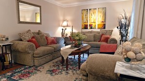 A cozy living room with two sofas, a coffee table, and a floral rug. - High Street Hideaway (New Milford)